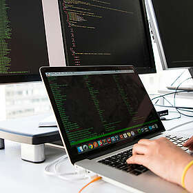 Eine Nahaufnahme eines Computerbildschirms, auf dem Codiersoftware mit leuchtend farbigem Text des Ruby-on-Rails-Codes angezeigt wird, hauptsächlich in Grün, Weiß und Orange auf dunklem Hintergrund.